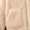 A close-up of a light beige plush hooded winter jacket with a visible seam detail.