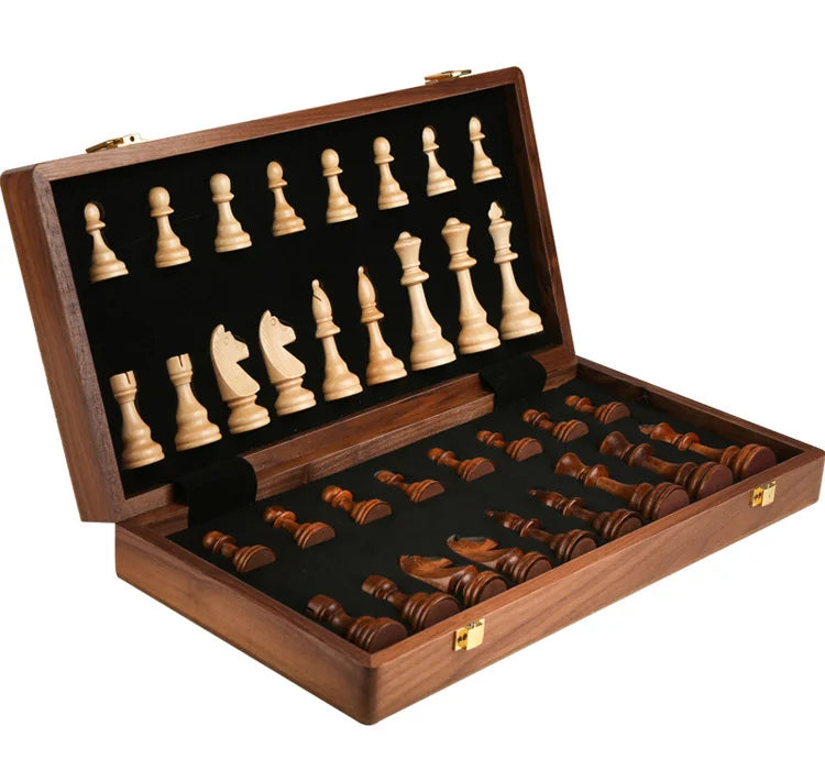 A handcrafted wooden folding chess set with solid walnut pieces displayed in an open wooden box.