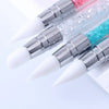 A close-up of a dual-ended silicone nail art dotting pen with crystal handles, showing pink and blue colors.