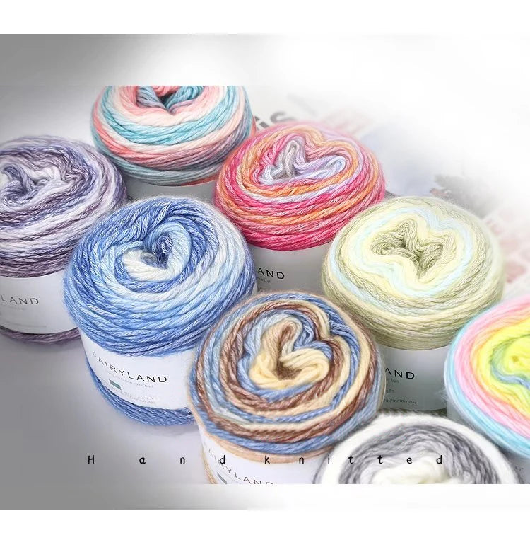 A collection of colorful gradient rainbow yarn spools in various shades and textures for knitting and crochet.