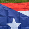 A large, folded Puerto Rico national flag banner featuring red and blue stripes and a white star on a dark blue field.