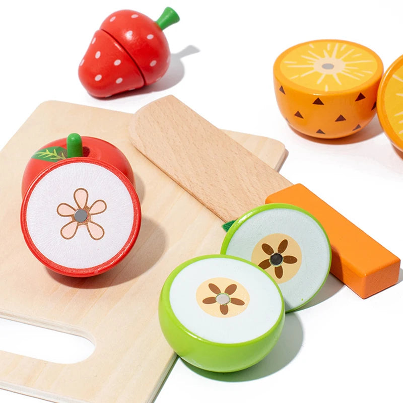 A wooden magnetic fruit cutting play set featuring a red strawberry, orange, and yellow fruit shapes with corresponding cutti