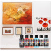 A set of twelve bottles of 24-color acrylic paint in various shades of red, orange, yellow, and blue.