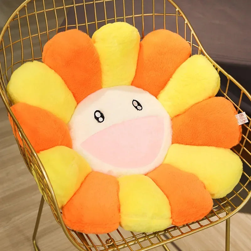 A large sunflower plush cushion with orange and yellow petals is displayed in a gold wire basket.