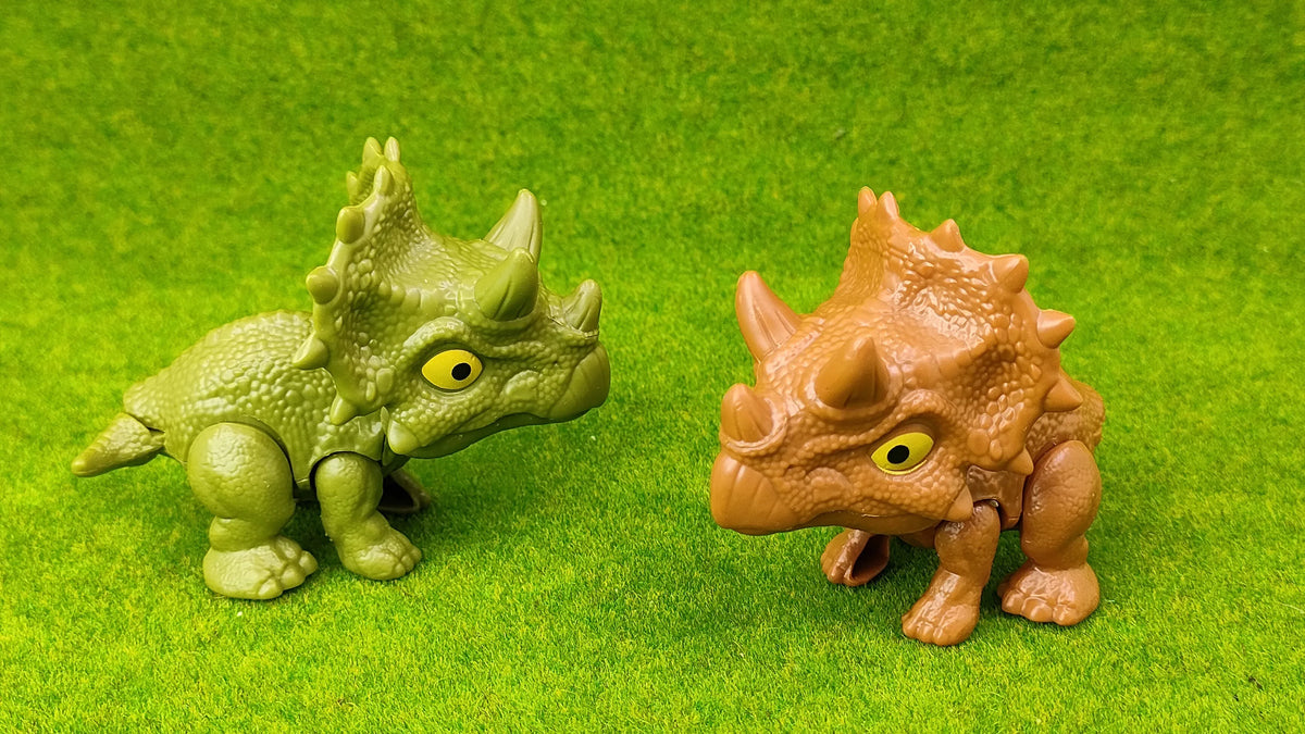 A small green dinosaur fossil model is placed on bright green textured surface.