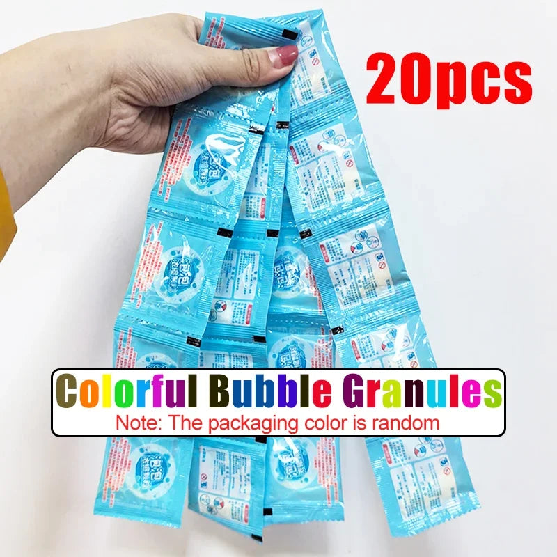 A hand holds a package of 20 colorful bubble granules for a dinosaur bubble gun.