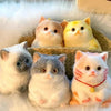 A collection of fluffy cat-shaped squishy stress relief toys in various colors and textures.