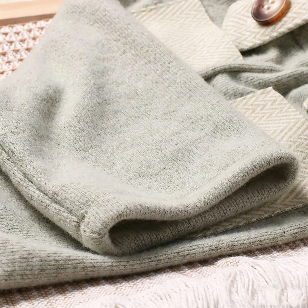 A light sage green knit romper and newsboy cap set for a newborn boy photography outfit.
