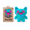 A bright blue Fuggler plush toy monster with large pink eyes and a purple version in its packaging.