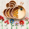 Natural wooden rainbow building blocks in various colors and shapes arranged on a beige textured surface.