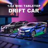 A miniature 1:64 scale drift car model in blue and black sits on a keyboard surface.