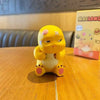 A yellow Milk Dragon blind box decorative figurine sitting on a wooden table.