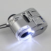 Silver handheld magnifying glass with an LED light, showing a bright beam.