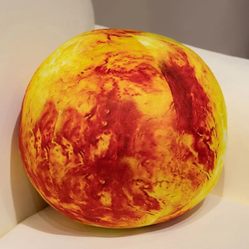 A round plush toy depicting a fiery, mottled yellow and red surface, resembling a solar body.