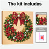 A Christmas wreath made of red and green beads, pearls, and gold accents, presented on a cardboard background.