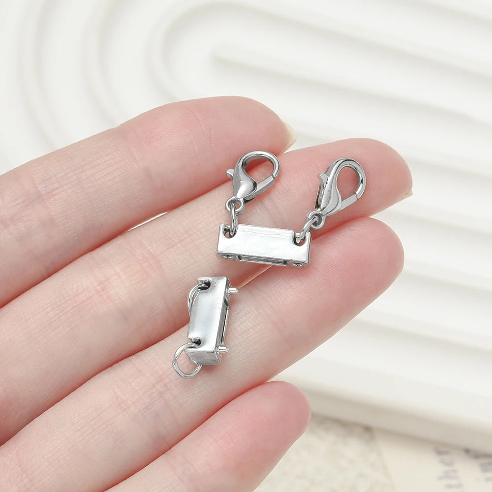 Silver magnetic layering clasps for necklaces and bracelets displayed on a hand