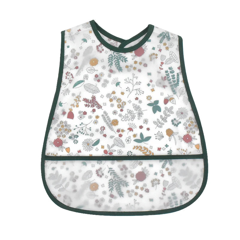 A white baby bib with a dark green trim featuring a watercolor cartoon pattern of various leaves and flowers.