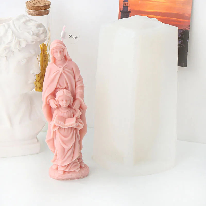 A pink silicone figure mold depicting the Virgin Mary and child, used for candle and resin crafting.