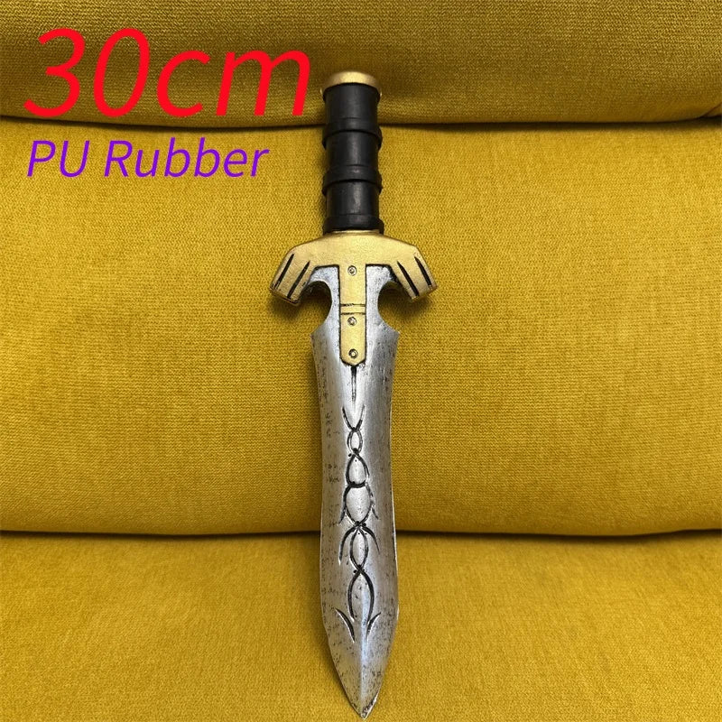 A silver dagger with a gold hilt and black grip is displayed on a yellow fabric background.