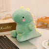 A soft, light green dinosaur plush toy resting on a laptop keyboard.