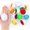 A hand holds multiple colorful, egg-shaped sorting toys for toddlers.