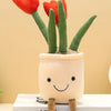 A cute plush toy of a tulip succulent with green stems and a smiling face, sitting in a white pot.
