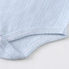 Light blue knitted cotton romper for babies with a gathered waist detail