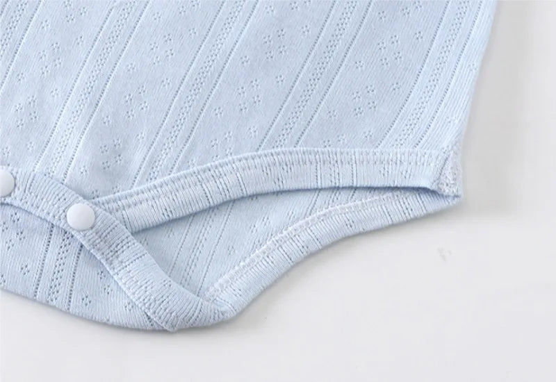 Light blue knitted cotton romper for babies with a gathered waist detail