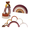 A set of soft silicone rainbow building blocks in various pastel and earthy tones arranged in a curved arc.