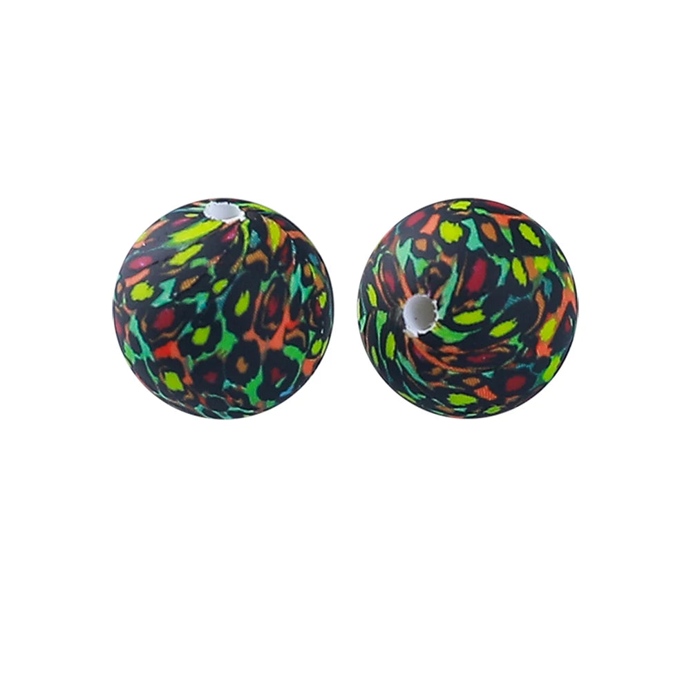 Two spherical silicone beads with an orange and green leopard print pattern.
