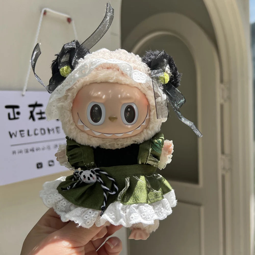 A 17cm mini doll outfit set featuring a light beige dress with green accents and a white ruffled hem.