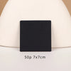 A black square jewelry display card with two small eyes is shown against a light background.