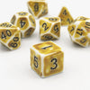 A collection of yellow and white polyhedral dice, including d4s, d6s, and d10s, scattered on a white surface.