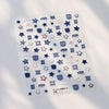 A sheet of nail art stickers featuring various star and geometric shapes in blue, pink, and gray tones.