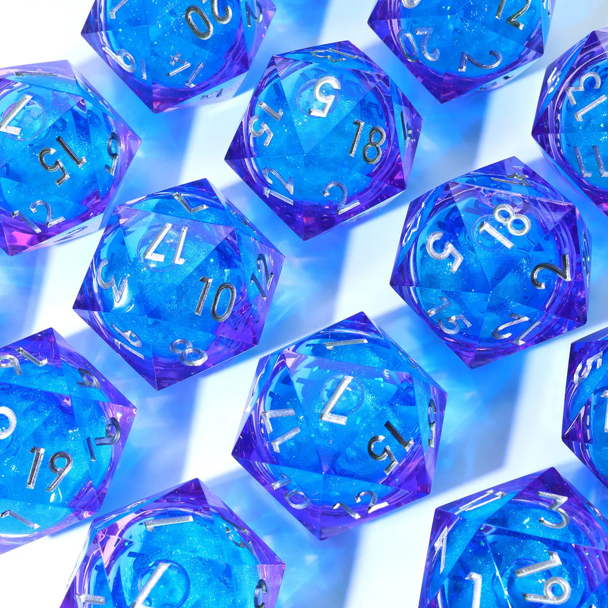A collection of handmade resin D20 dice featuring large blue and purple liquid swirls.