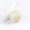 A roll of light yellow cotton nylon macrame cord for jewelry making and crafts.