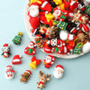 A pile of colorful 3D Christmas Santa and tree silicone beads used for festive craft jewelry charms.