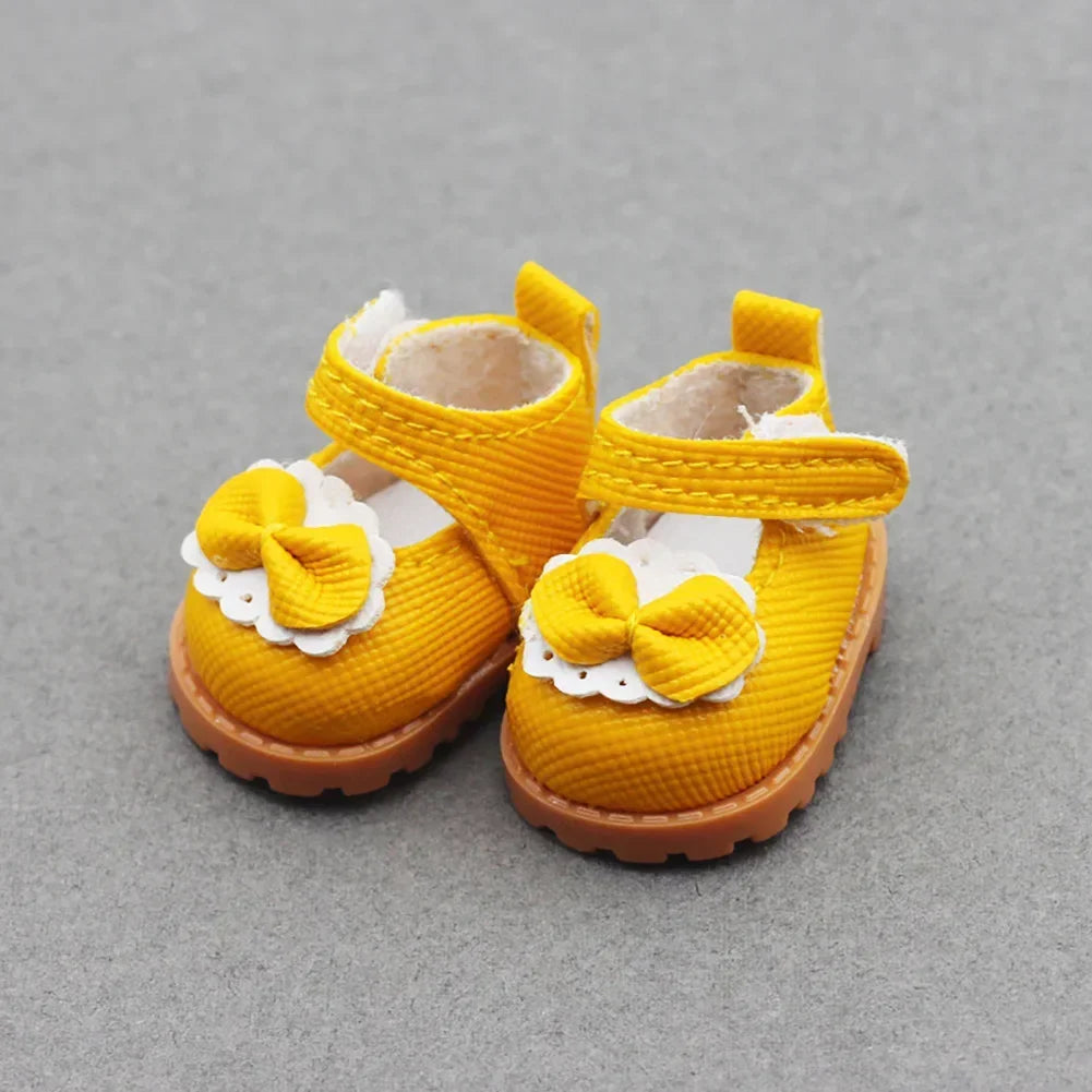 A pair of yellow casual sneakers with white bow details for 17cm Labubu dolls.