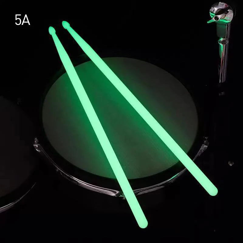 Pair of bright green glow-in-the-dark nylon drumsticks shown against a dark background.