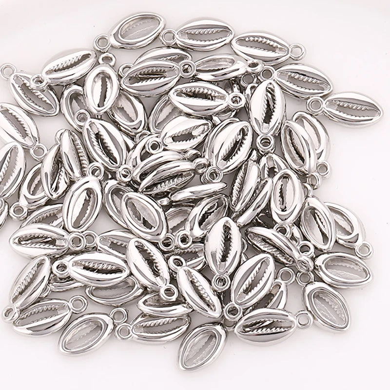 A collection of 50 small silver plastic seashell charms for jewelry making, featuring bohemian cowrie and conch pendants.