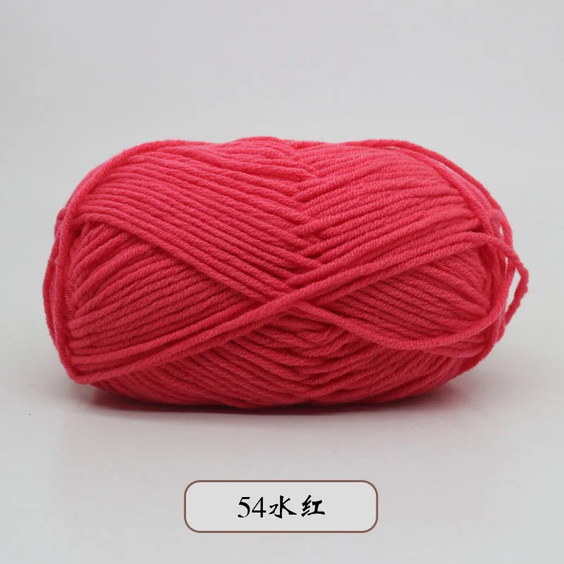 A ball of bright coral red pre-dyed milk cotton yarn for knitting and crochet.
