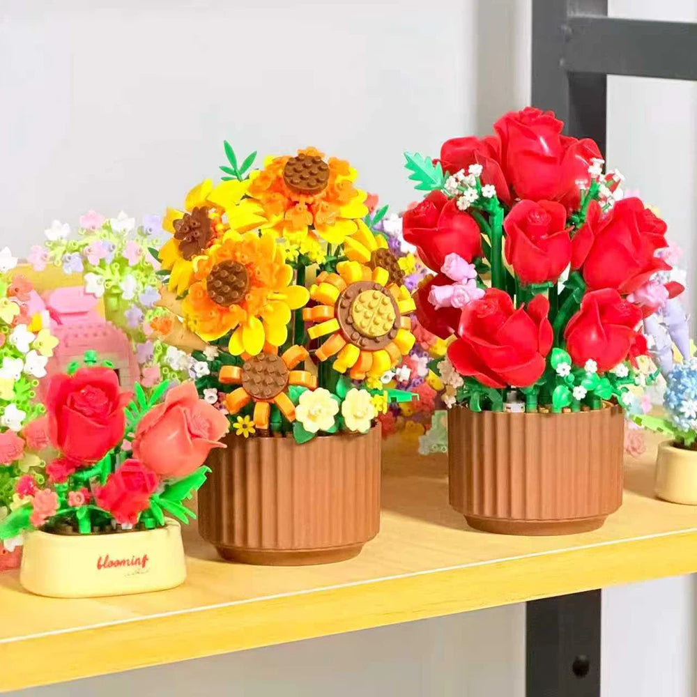 A bouquet of red roses and yellow sunflowers arranged in terracotta pots.
