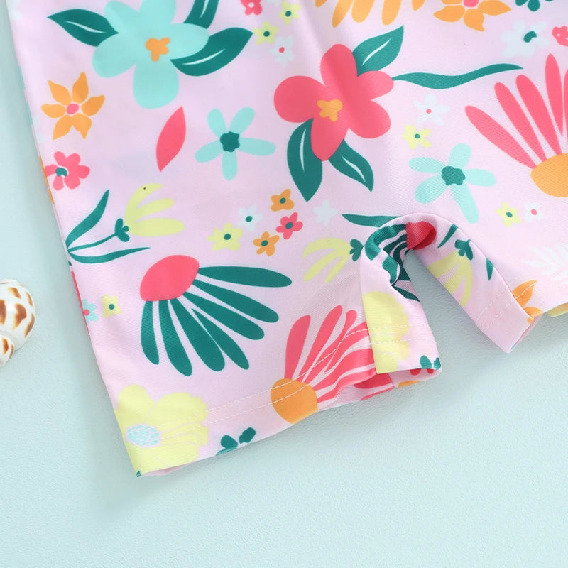 Pink baby rash guard swimsuit with a colorful floral print featuring green, pink, and yellow leaves and flowers.
