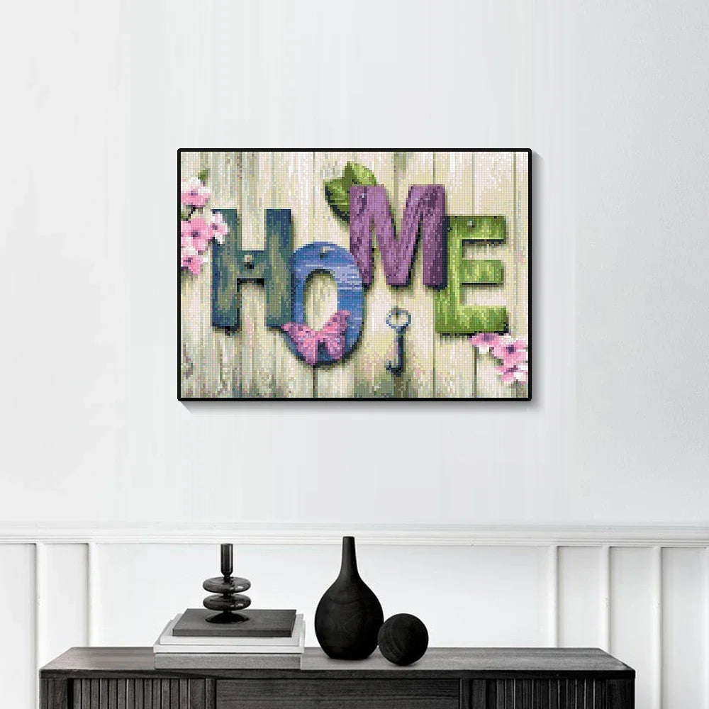 A piece of art featuring the word HOME in various textured paint colors and pink floral accents.