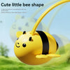 A yellow bee-shaped toy with black stripes is shown floating in a green outdoor setting.