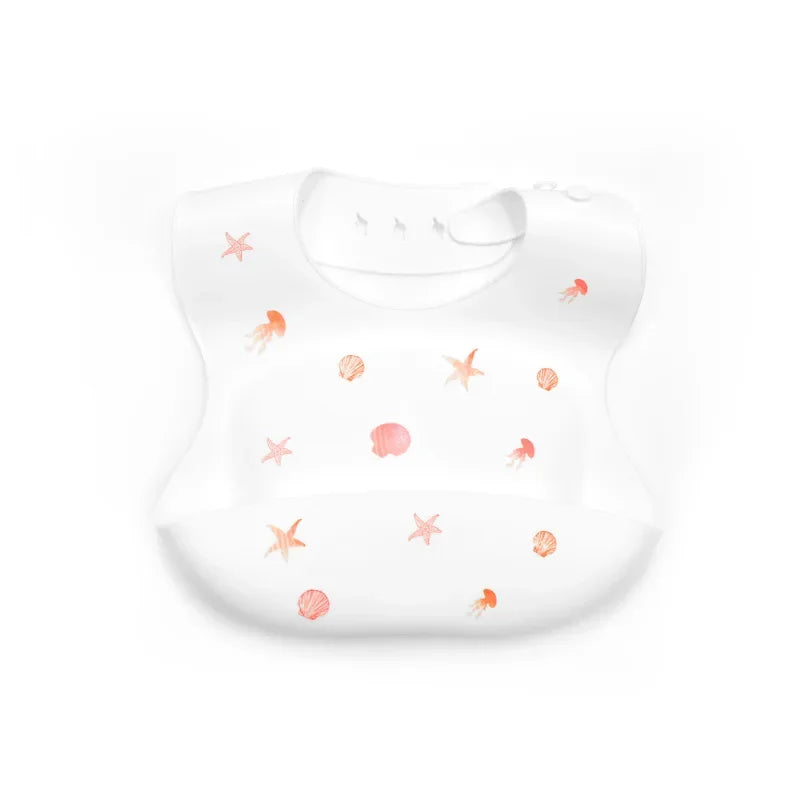 A white silicone baby bib with an adjustable neck featuring small pink starfish and coral designs.