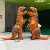 An inflatable orange and gray Tyrannosaurus Rex costume standing on a white floor.