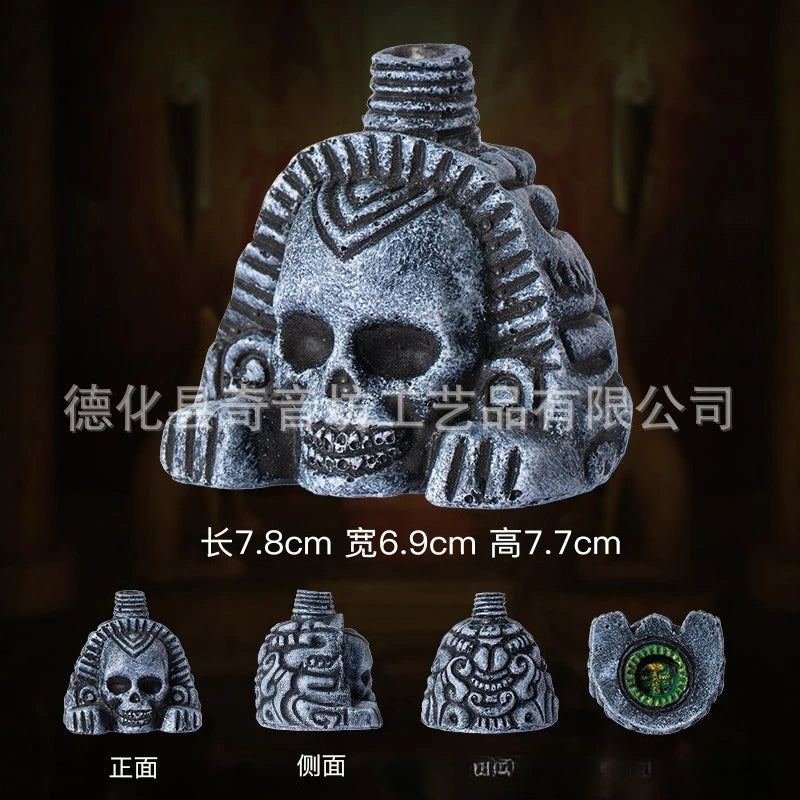 A gray stone Aztec death whistle skull shown from the front, side, back, and top views.