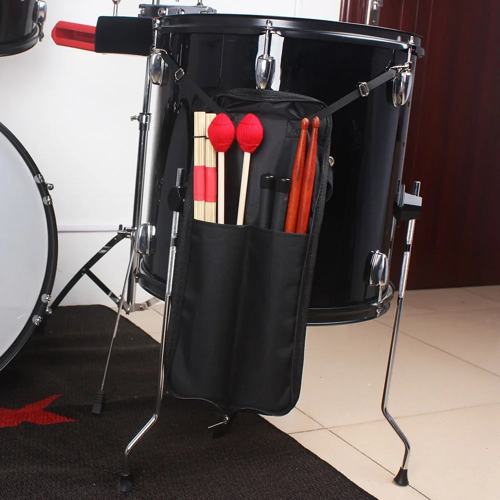 A black drumstick carrier bag with a handle and wooden drumsticks is displayed on a stand.