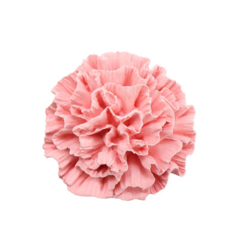 A pink ruffled flower made of silicone mold used for soap, candle, and cake decorating.